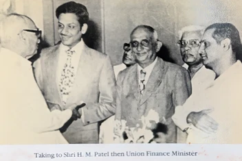 Black and white photo of Ajay 'Dadu' Rungta shaking hands and speaking with Shri H.M. Patel, then Union Finance Minister.