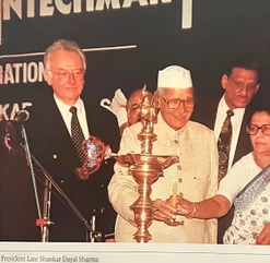 Close-up of Ajay Rungta beside President Shankar Dayal Sharma, who is lighting a large, traditional Indian oil lamp.